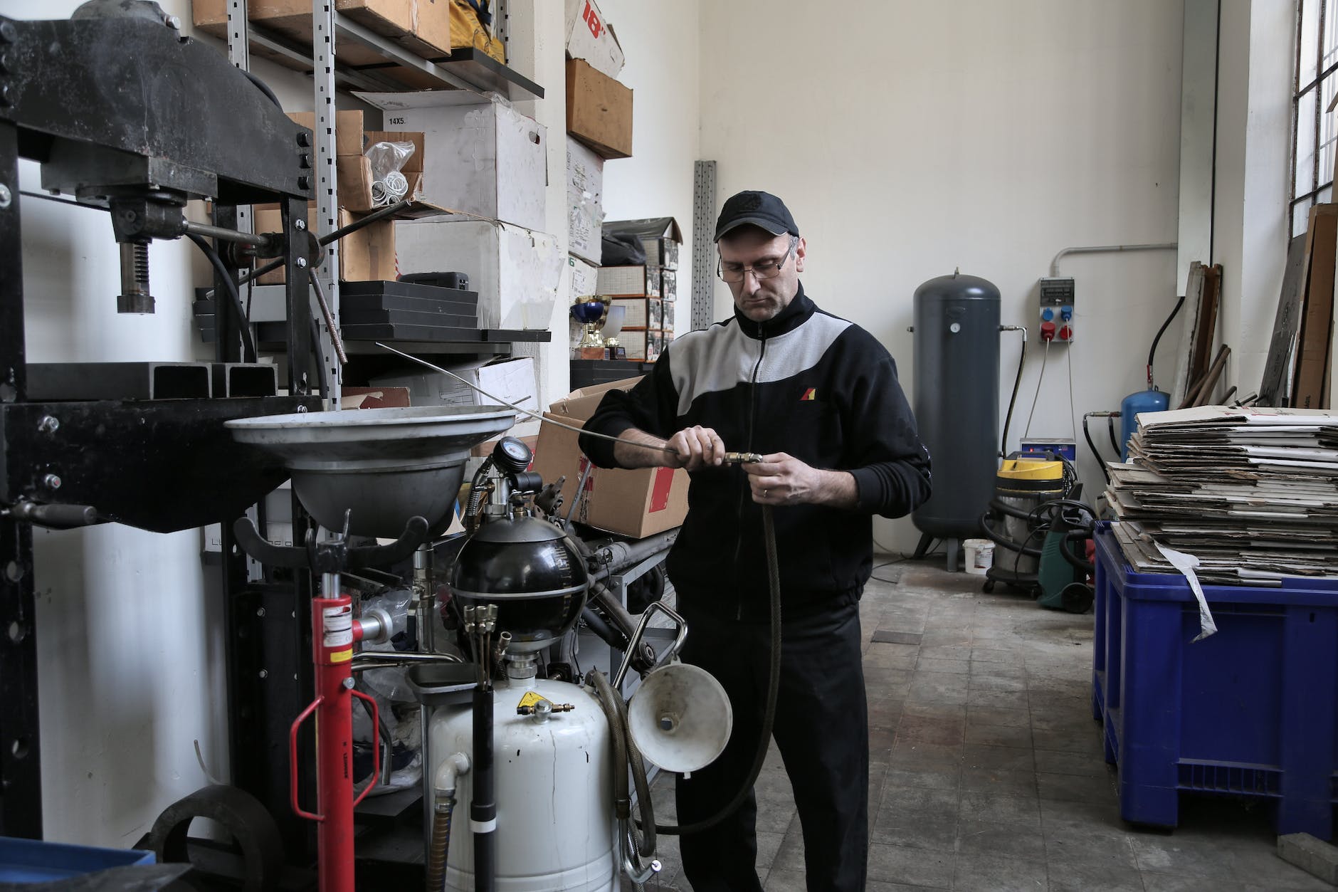 focused mechanic repairing compressor hose in workshop