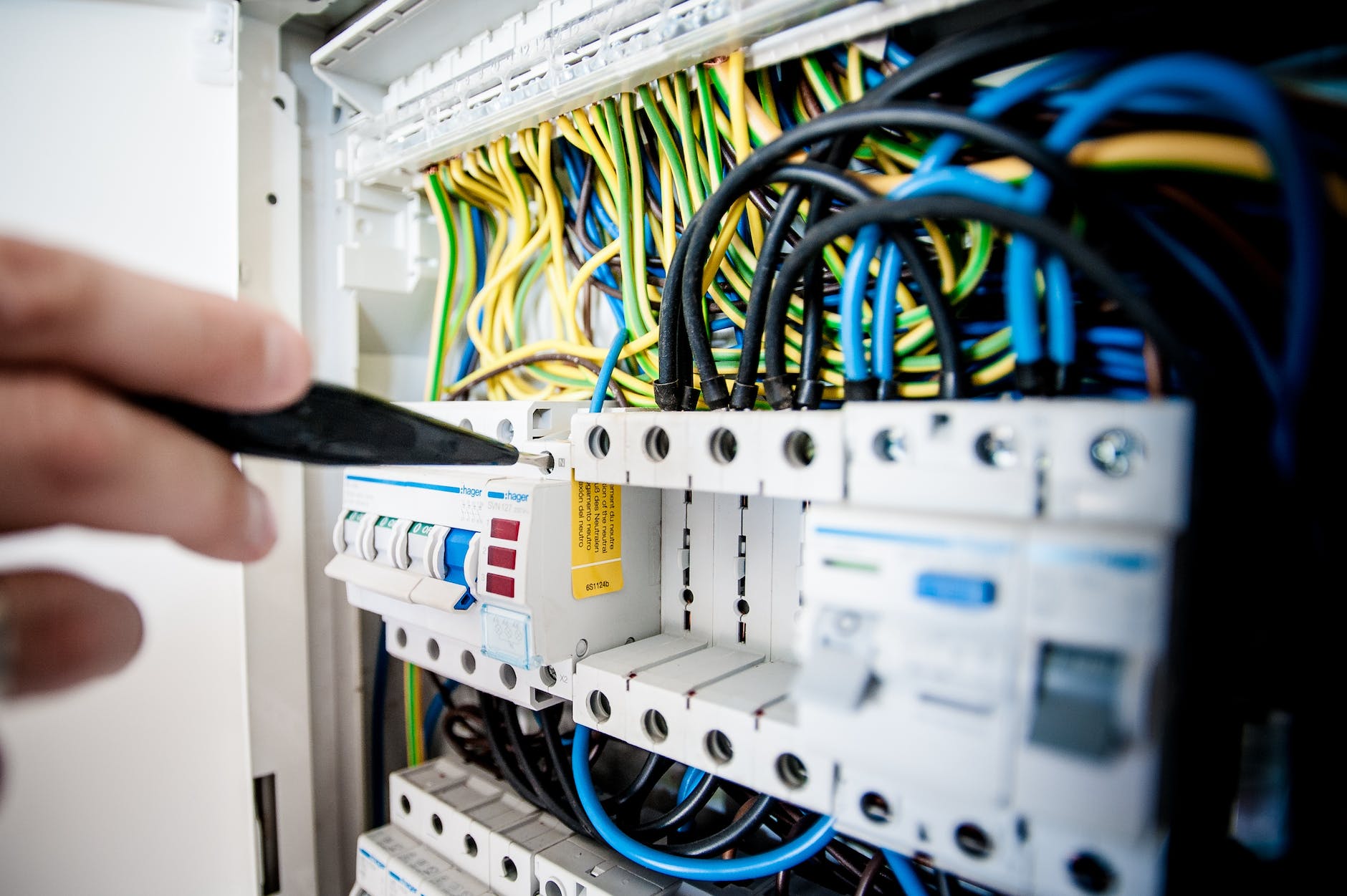 electrician fixing an opened switchboard