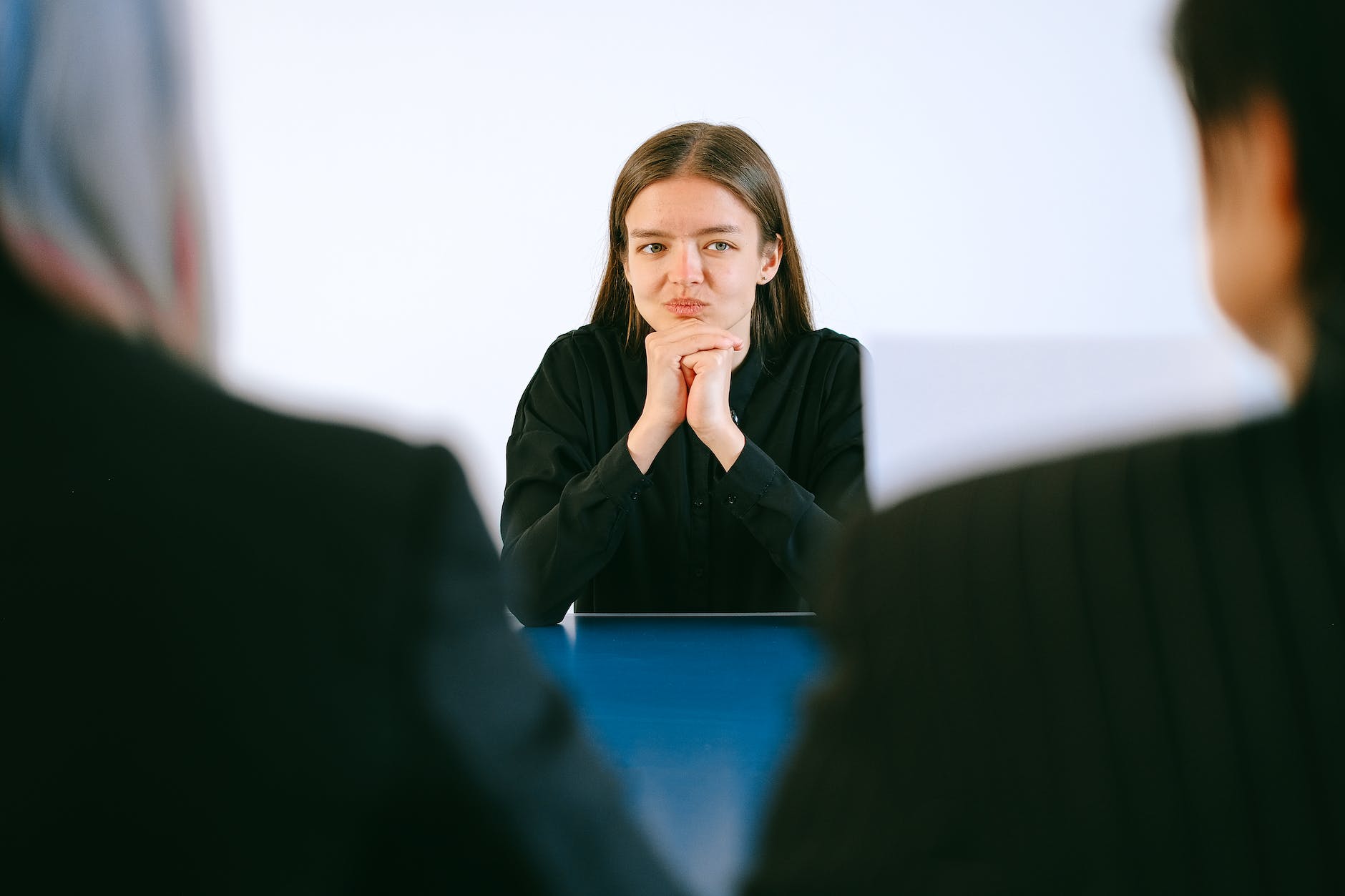 woman in black blazer sitting being interview