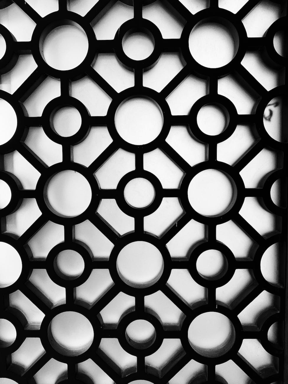 black room divider with geometric design on white surface