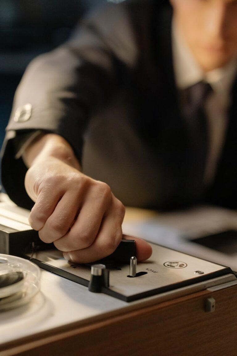 a detective turning the switch of a vintage recorder